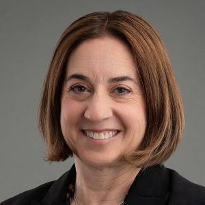 Hara is wearing a black shirt. She has short brown hair and brown eyes.