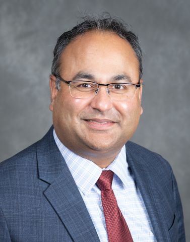 Amish in a blue suit and red tie. He's wearing glasses