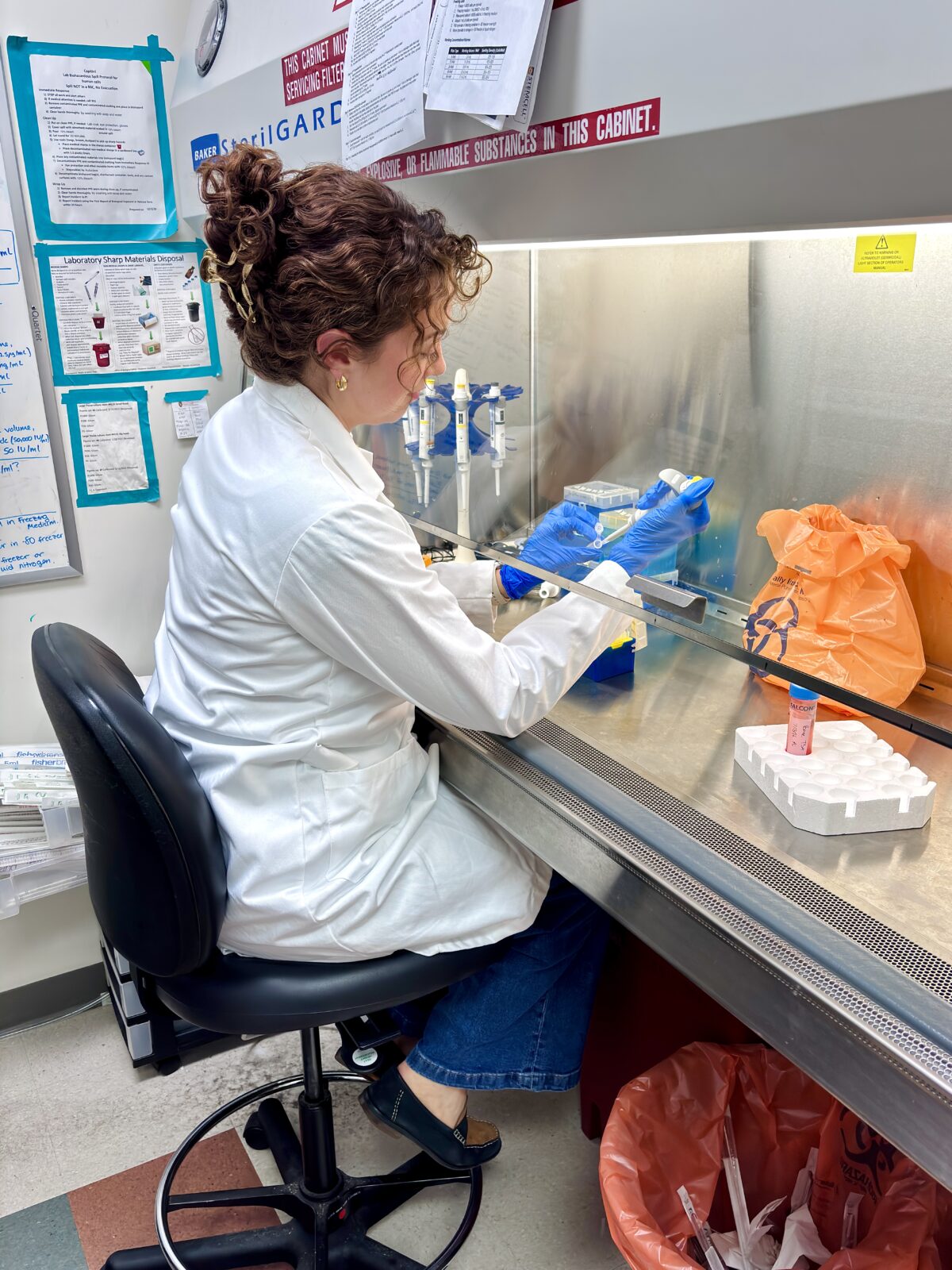 Portia in a lab coat near a biosafety cabinet